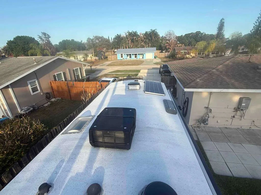 Bolt RV technician replacing a rooftop AC unit on an RV at a Florida campground