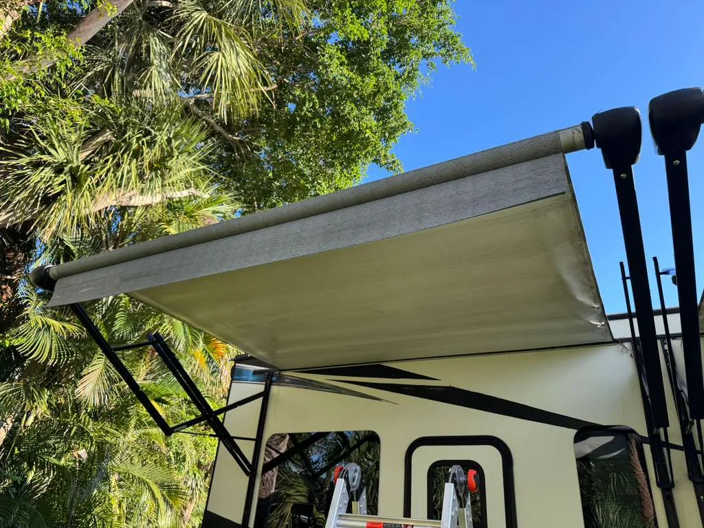 Bolt RV technician replacing an RV awning at a Florida campground