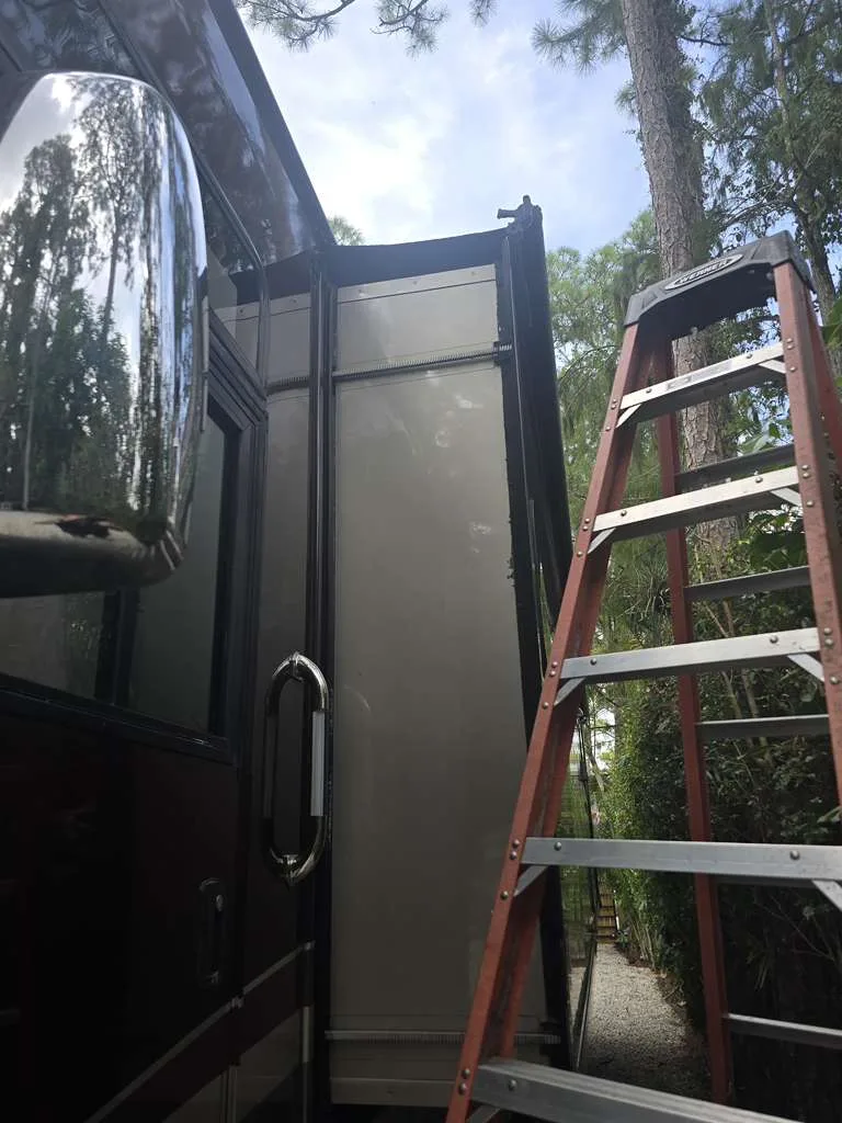 Bolt RV technician working on a stuck slide-out at a Florida campsite